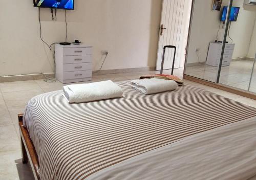 a bedroom with a large bed with two pillows on it at Crisba B&B in Freetown