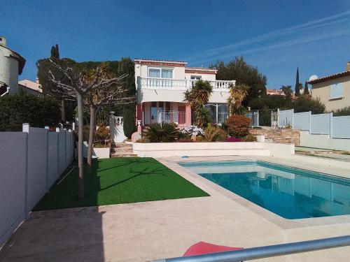 une maison avec une piscine dans une cour dans l'établissement Villa L'Audaline, à Roquebrune-sur Argens