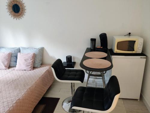 Cette chambre comprend un lit, une télévision et une table. dans l'établissement Provençal-style apartment, à Aix-en-Provence