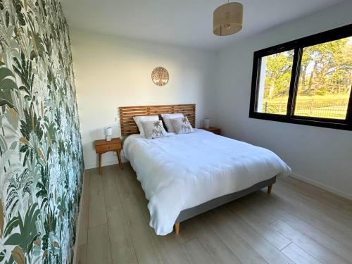 une chambre avec un lit et une grande fenêtre dans l'établissement BelleVue - Jardin-Montagne-Calme, à Rivière-Saas-et-Gourby