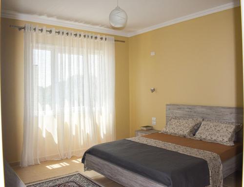 a bedroom with a bed and a large window at J & J Holiday Home Vala Mar in Hamallë