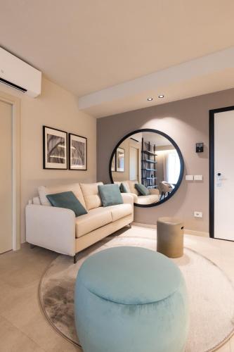 a living room with a couch and a round mirror at Stemor Visionary Apartments in Desenzano del Garda