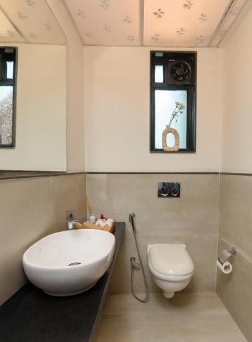 a bathroom with a white sink and a toilet at Nistula Luxury Pool Villa C3 in Assagao in Assagao