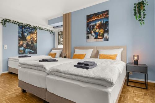 two beds in a bedroom with blue walls at JASPER - Balkon, BBQ, PS5, Flexbetten - Zentral & 15min in Willingen in Brilon