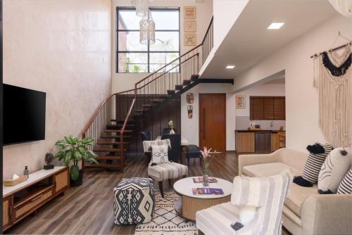 a living room with a couch and a staircase at Nistula Luxury Pool Villa C3 in Assagao in Assagao