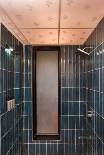 a bathroom with blue tiled walls and a mirror at Nistula Luxury Pool Villa C3 in Assagao in Assagao