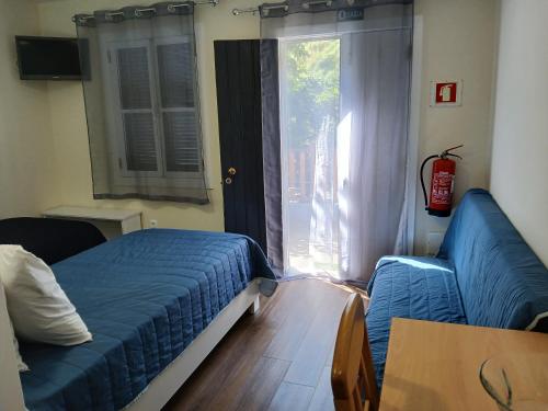 a bedroom with a bed and a couch and a window at casa da fajã in Funchal