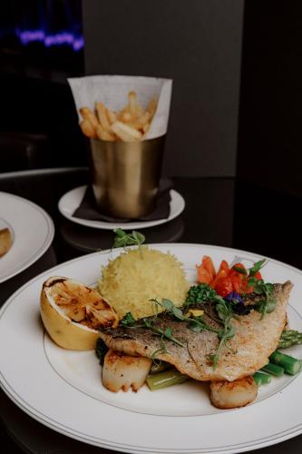a plate of food with fish and potatoes and french fries at Hyatt Regency London Albert Embankment in London