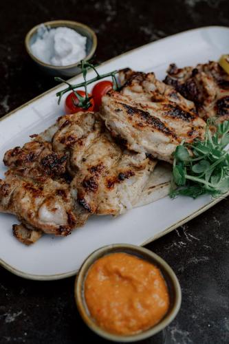 a plate of food with meat and sauce on a table at Hyatt Regency London Albert Embankment in London