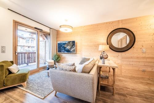 un salon avec un canapé et un miroir dans l'établissement Apartment Altum, Morzine - by EMERALD STAY, à Morzine