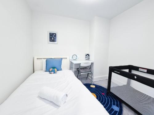 a bedroom with a white bed and a desk at Hamptons Style 2BR & kid room w view in Olympic Park in Sydney