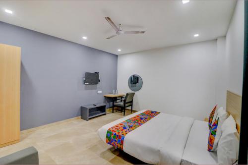 a bedroom with a bed and a table with a tv at FabHotel Premium Kashi in Varanasi