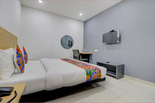 a bedroom with a bed and a desk and a tv at FabHotel Premium Kashi in Varanasi