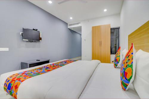 a bedroom with a large bed and a tv at FabHotel Premium Kashi in Varanasi