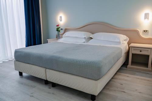 a bedroom with a large bed with white sheets and pillows at AHG Riva Del Sole Hotel - Adults Only in Moniga