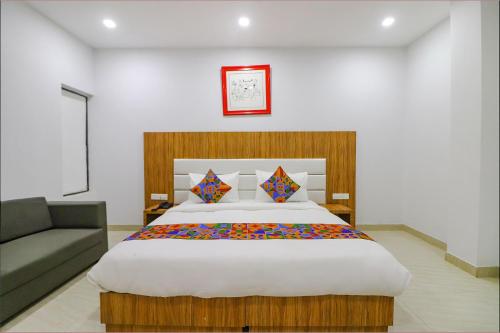 a bedroom with a large bed and a couch at FabHotel Premium Kashi in Varanasi