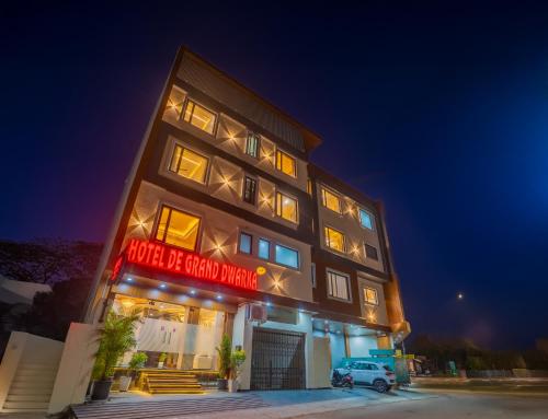a building with a car parked in front of it at Hotel De Grand Dwarka-Near Jaipur Airport in Jaipur