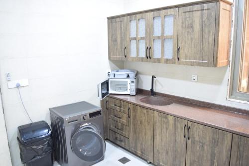 a bathroom with a washing machine and a microwave at شقق دار الزيني - Dar Alzainy Apartments in Baghdad