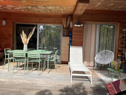 un patio avec une table et des chaises sur une terrasse dans l'établissement Residence Cala Sultana -Baie Santa Giulia - rez jardin 1ere ligne, à Porto-Vecchio