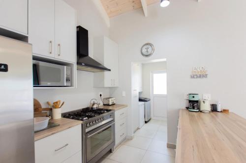 a kitchen with white cabinets and a stove top oven at Founders Villa in Britannia Bay