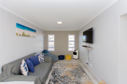 a living room with a couch and a flat screen tv at Founders Villa in Britannia Bay