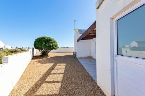 a door to a white building with a window at Founders Villa in Britannia Bay