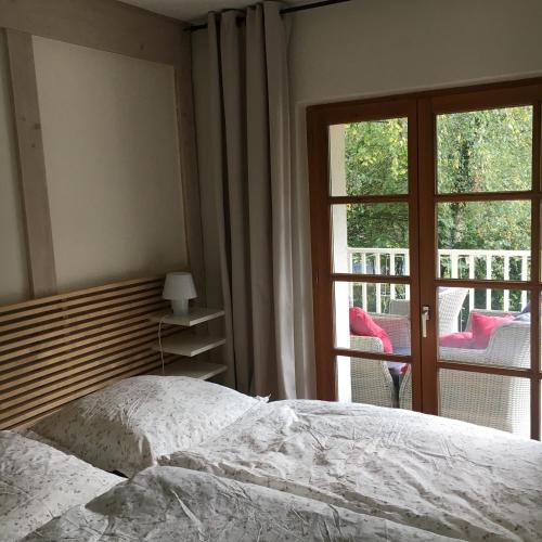 a bedroom with a bed and a window with a balcony at Waldblick in Bleckede