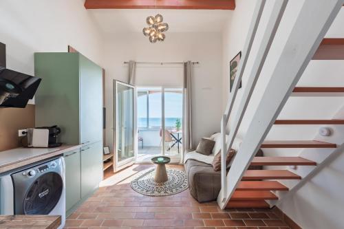 un escalier menant à une cuisine et un salon donnant sur l'océan. dans l'établissement Appart le Grand Bleu Saint Aygulf, à Fréjus