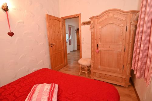 a bedroom with a red bed and a wooden door at Suite Sissi in Warnemünde