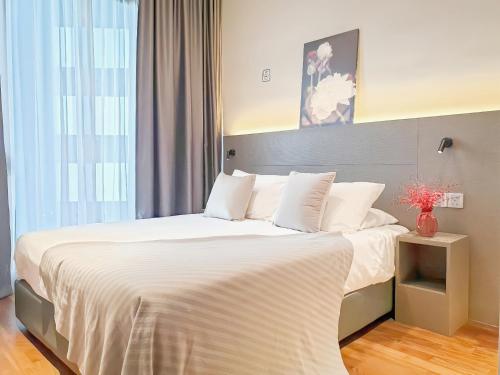 a bedroom with a large bed with white sheets and pillows at Geo 38 Residence Genting Highlands in Genting Highlands