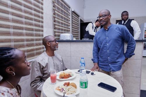 a group of people sitting around a table with food at Peace Luxury Hotel and Apartment in Jahi