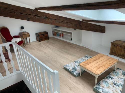 a living room with a table and a chair at Maison calme - Rue piétonne - Ardeche - ViaRhona - Dolce Via in La Voulte-sur-Rhône