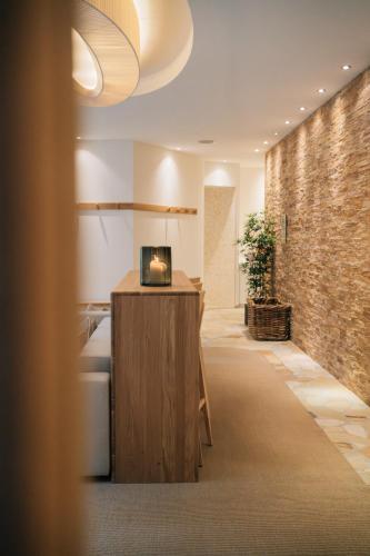 a lobby with a desk and a brick wall at Klostermaier Hotel & Restaurant in Icking