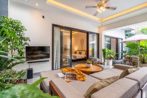 ケロボカンにあるVilla Taj - Luxury 3-bedroom Pool Villa Near Seminyakのソファとテレビのあるリビングルーム