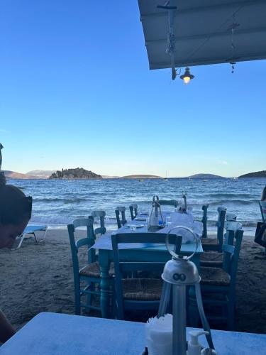 a table on the beach with the ocean in the background at Villa Artemis Nafplion in Tolo