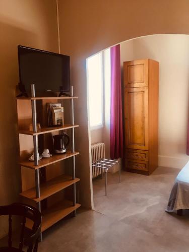 Cette chambre dispose d'une télévision et d'une étagère avec une télévision. dans l'établissement Le Lion d Or chb double wifi 1, à Écueillé
