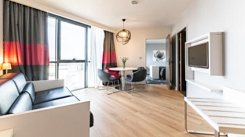 a living room with a couch and a table at Holiday Inn Dijon Toison D'or by IHG in Dijon