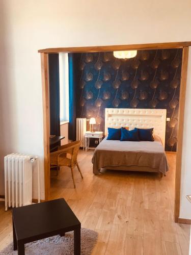 une chambre avec un grand lit avec des oreillers bleus dans l'établissement Le Lion d Or chb double wifi 9, à Écueillé