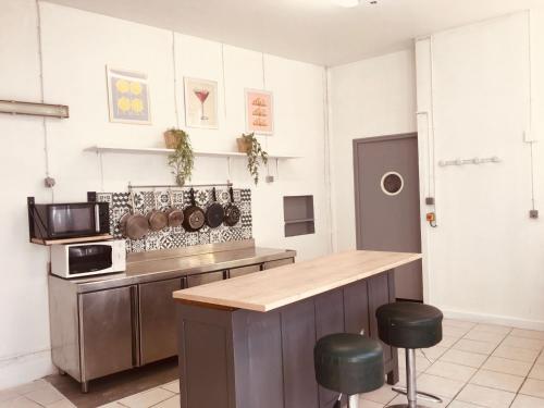 une cuisine avec un comptoir et quelques casseroles et poêles dans l'établissement Le Lion d'Or chb double wifi 4, à Écueillé