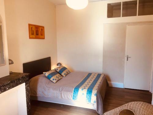 Cette petite chambre comprend un lit avec des oreillers bleus. dans l'établissement Le Lion d'Or chb double wifi 4, à Écueillé