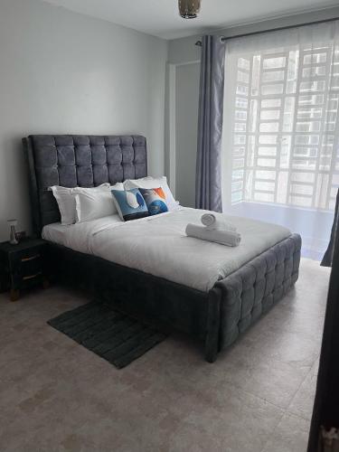 a large bed in a bedroom with a large window at Treands Apartments in Nakuru
