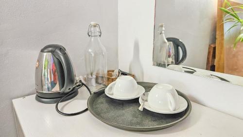 a tea kettle and two cups on a counter at Arista Villa in Ukulhas