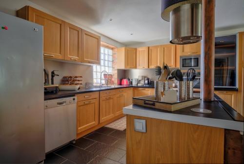 una cucina con mobili in legno e un frigorifero bianco di Villa des Albizzias a La Teste-de-Buch