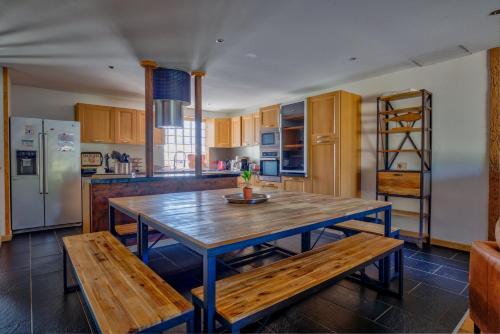 una cucina con tavolo in legno e panche di Villa des Albizzias a La Teste-de-Buch