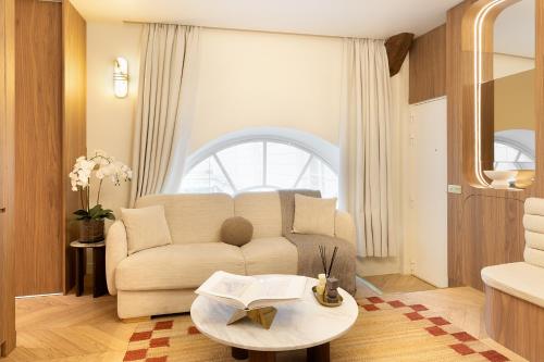 un salon avec un canapé et une table dans l'établissement Maison Galante - Apartments in Grand Boulevards - Passage Panorama, à Paris