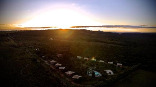 an aerial view of the sun setting over a field at Pousada Refúgio da Serra in Pirenópolis