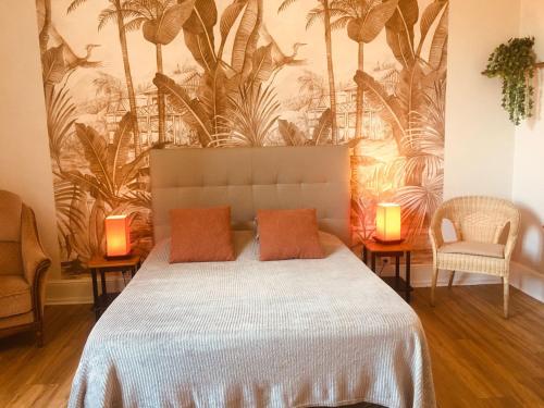 a bedroom with a bed with two chairs and two lamps at Le Lion d'Or chb 4 pers wifi 11 in Écueillé