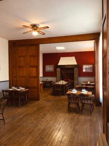 a dining room with tables and chairs and a fireplace at Le Lion d'Or chb 4 pers wifi 11 in Écueillé