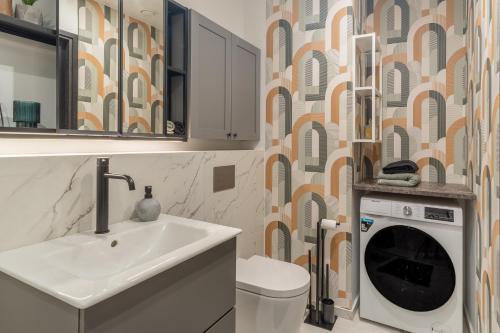 un bagno con lavandino e lavatrice di Caramel apartment a Pärnu