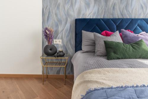 un letto con testiera blu e un tavolino di Caramel apartment a Pärnu